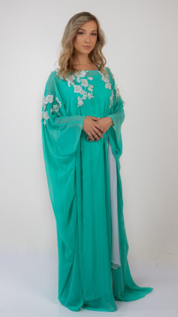 Woman posing in jalabiya style dress green colour decorated with white sequin flowers