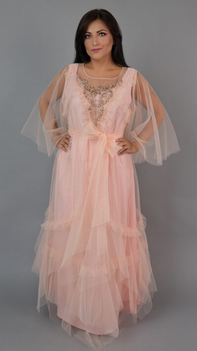 woman posing in peach colour long dress made of tulle embroidered with crystals at the front